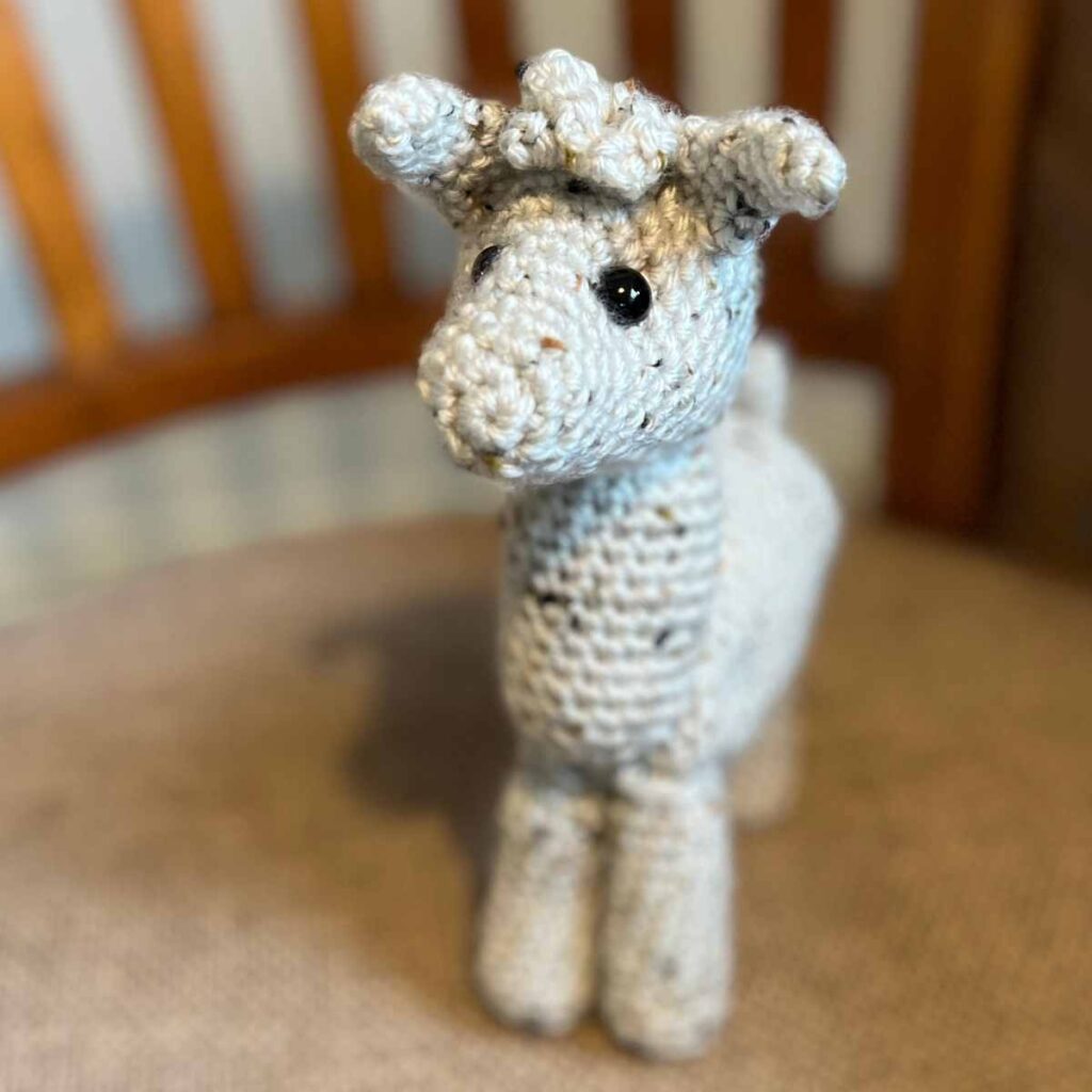 photo of a cream yarn crocheted llama