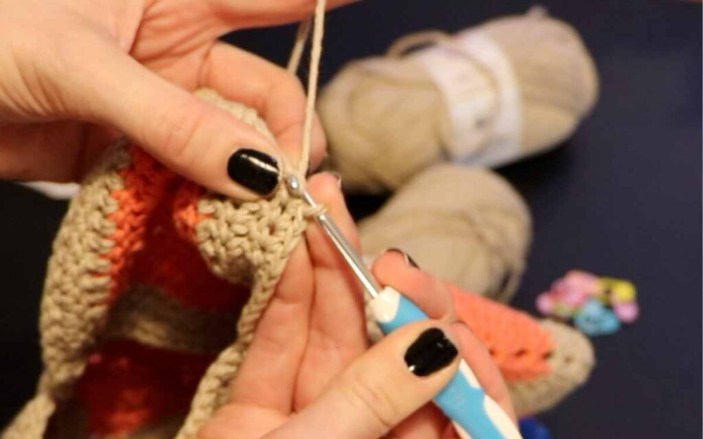 a photo showing single crocheting around the edge of the granny square bag