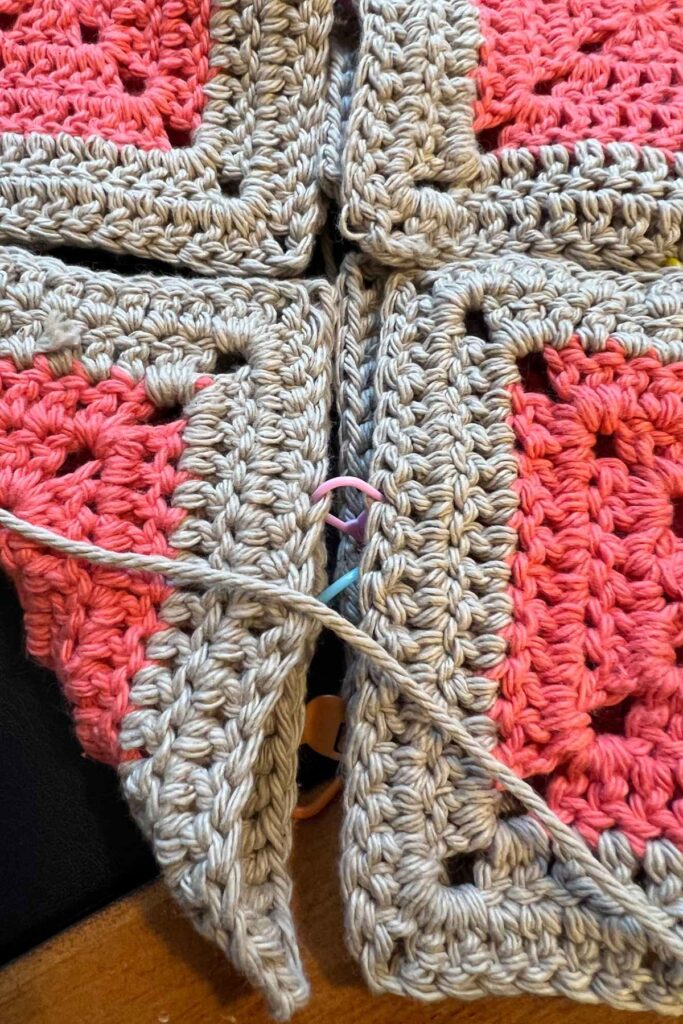 photo demonstrating how to stitch marker the sides of the granny squares together