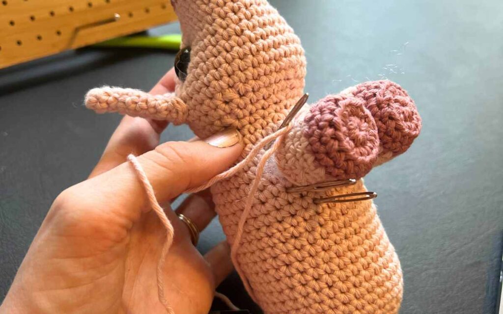image showing my crochet piglet's legs being attached