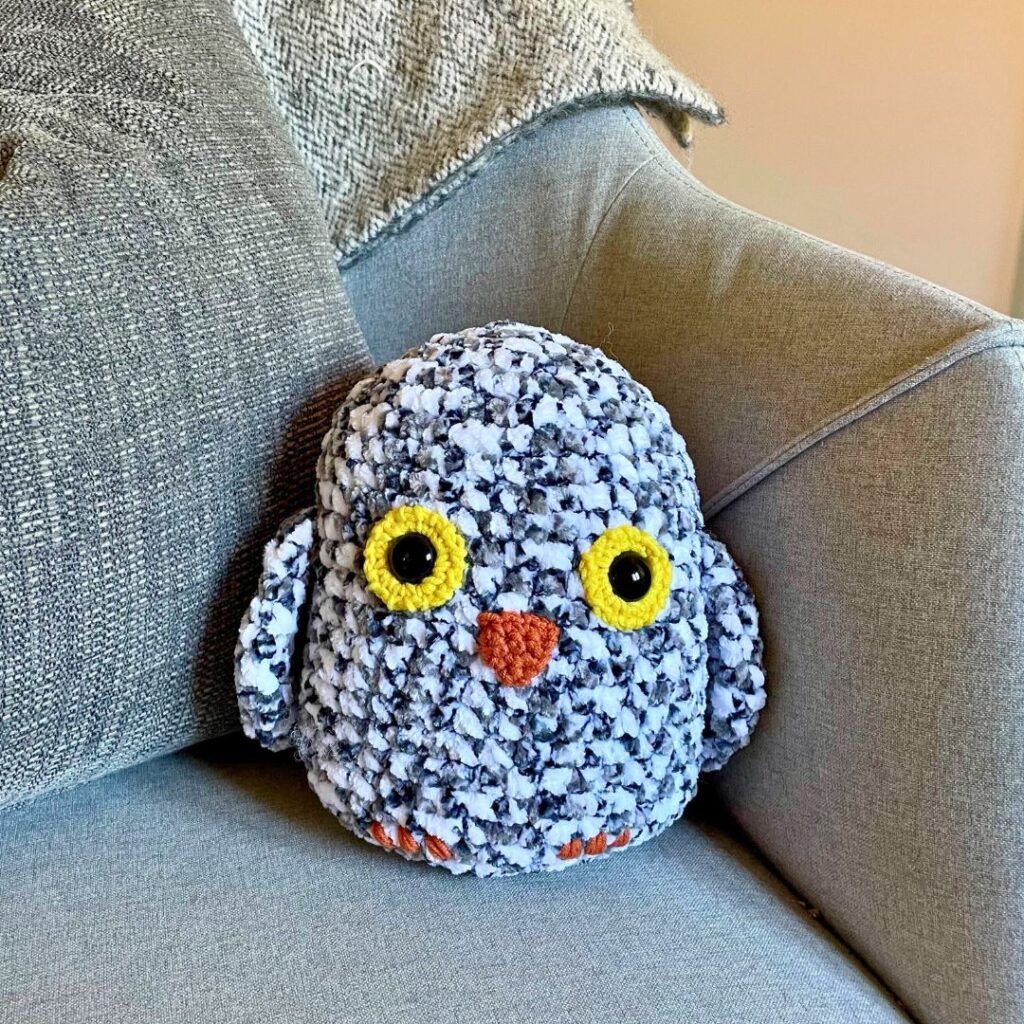 finished squishy crochet owl sitting in an armchair