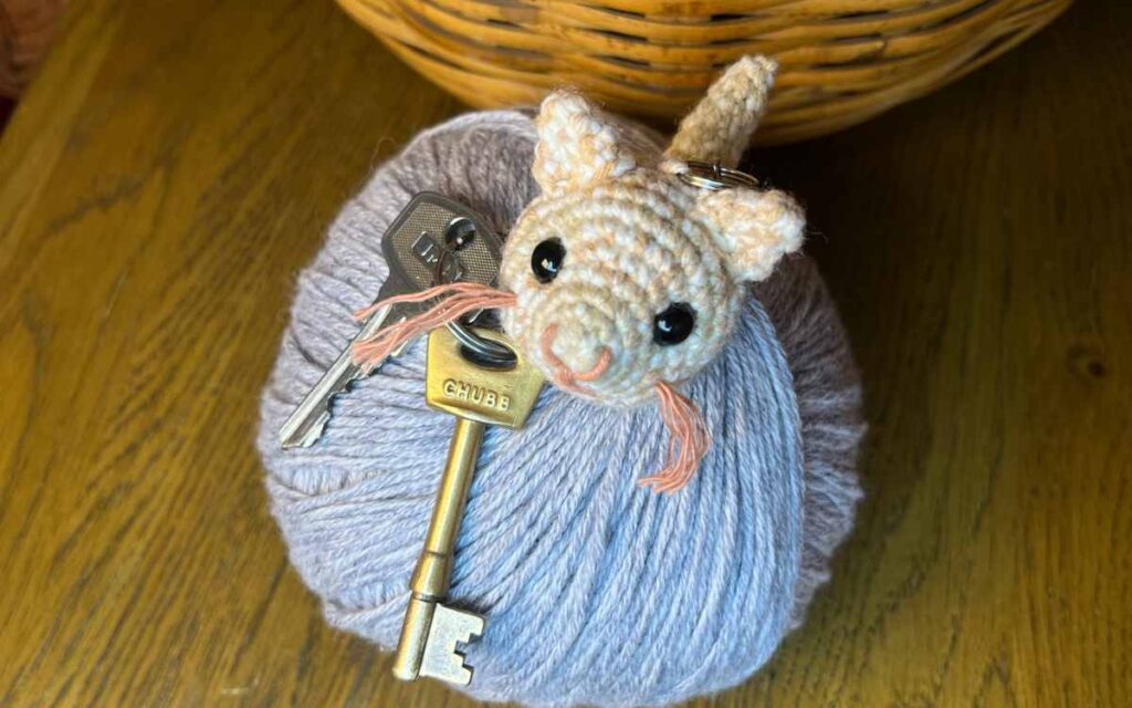picture of my amigurumi kitten keychain on some yarn