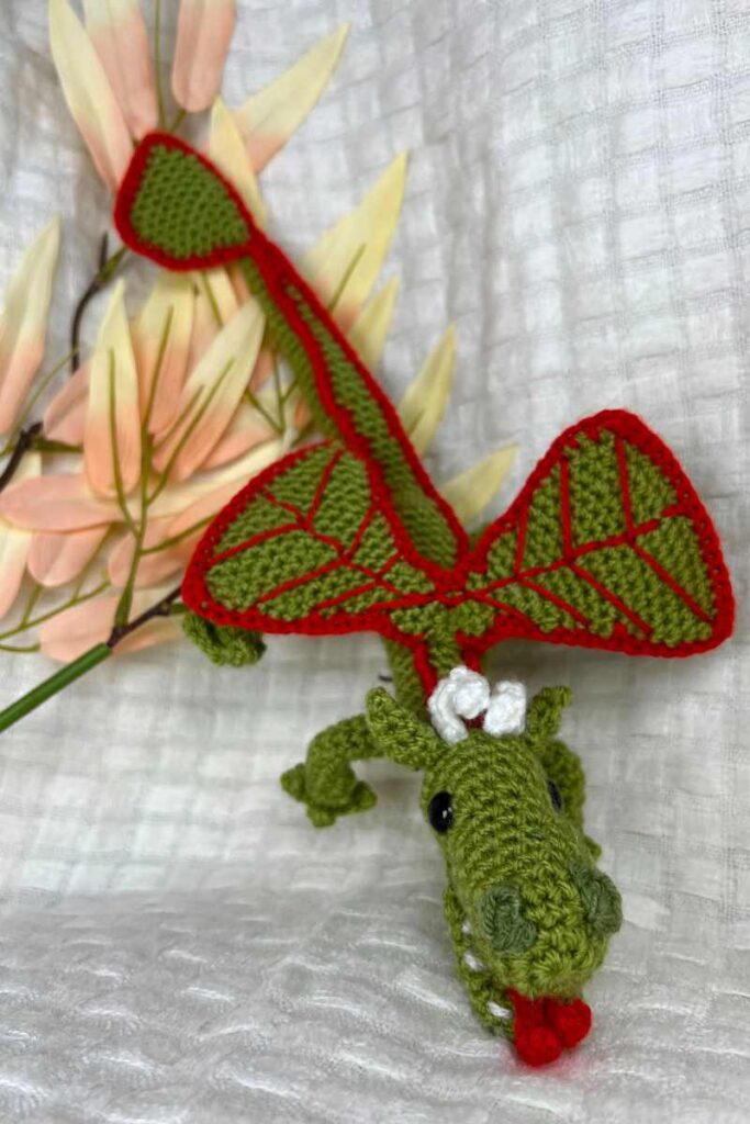 image of the crochet dragon on a blanket