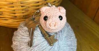 picture of amigurumi pig keychain on some yarn