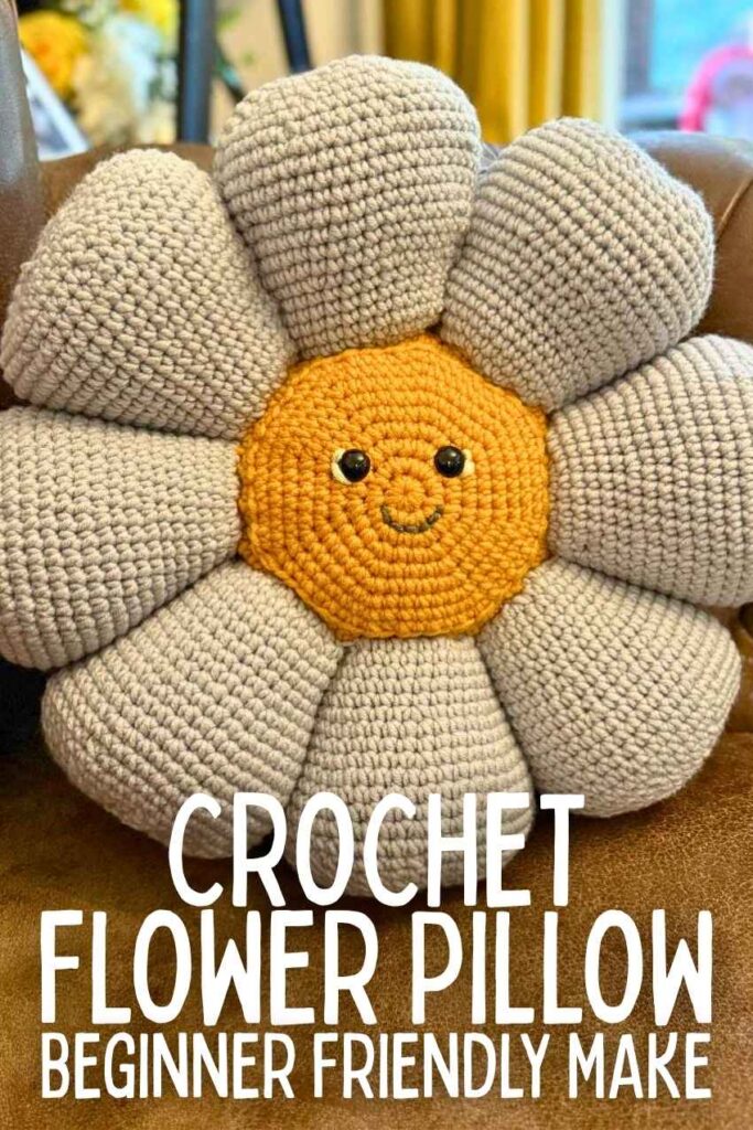photo of a crochet flower pillow with a face