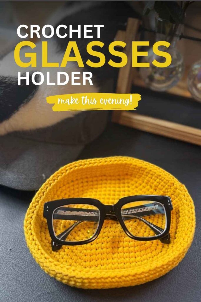 photo of a pair of black framed glasses sitting in a yellow crochet glasses holder