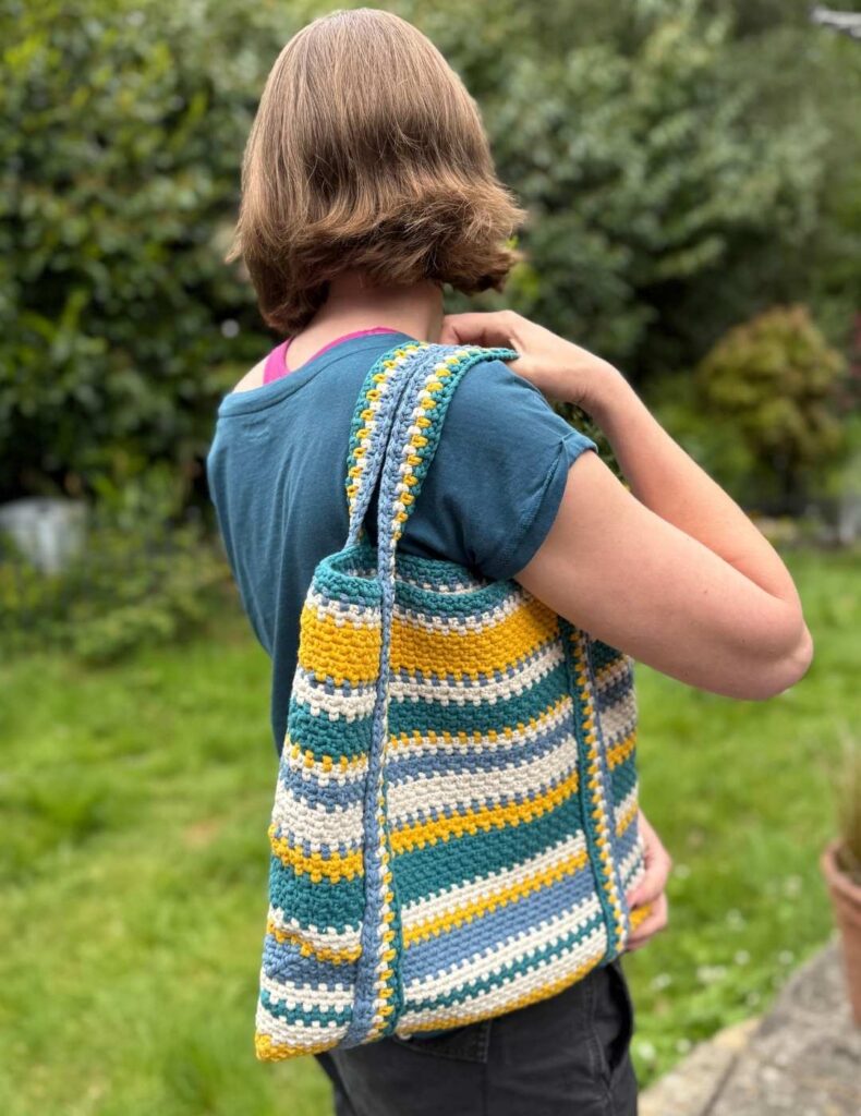 wearing my finished crochet beach bag in the garden
