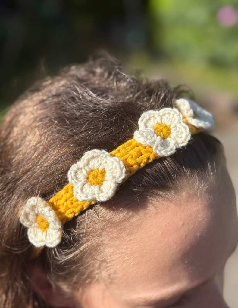 my daughter wearing the crochet headband in the garden